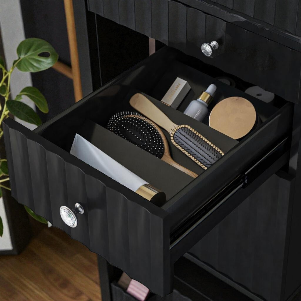 Open black drawer with wooden hairbrushes, cosmetic tube, dropper bottle, and round container on wooden floor