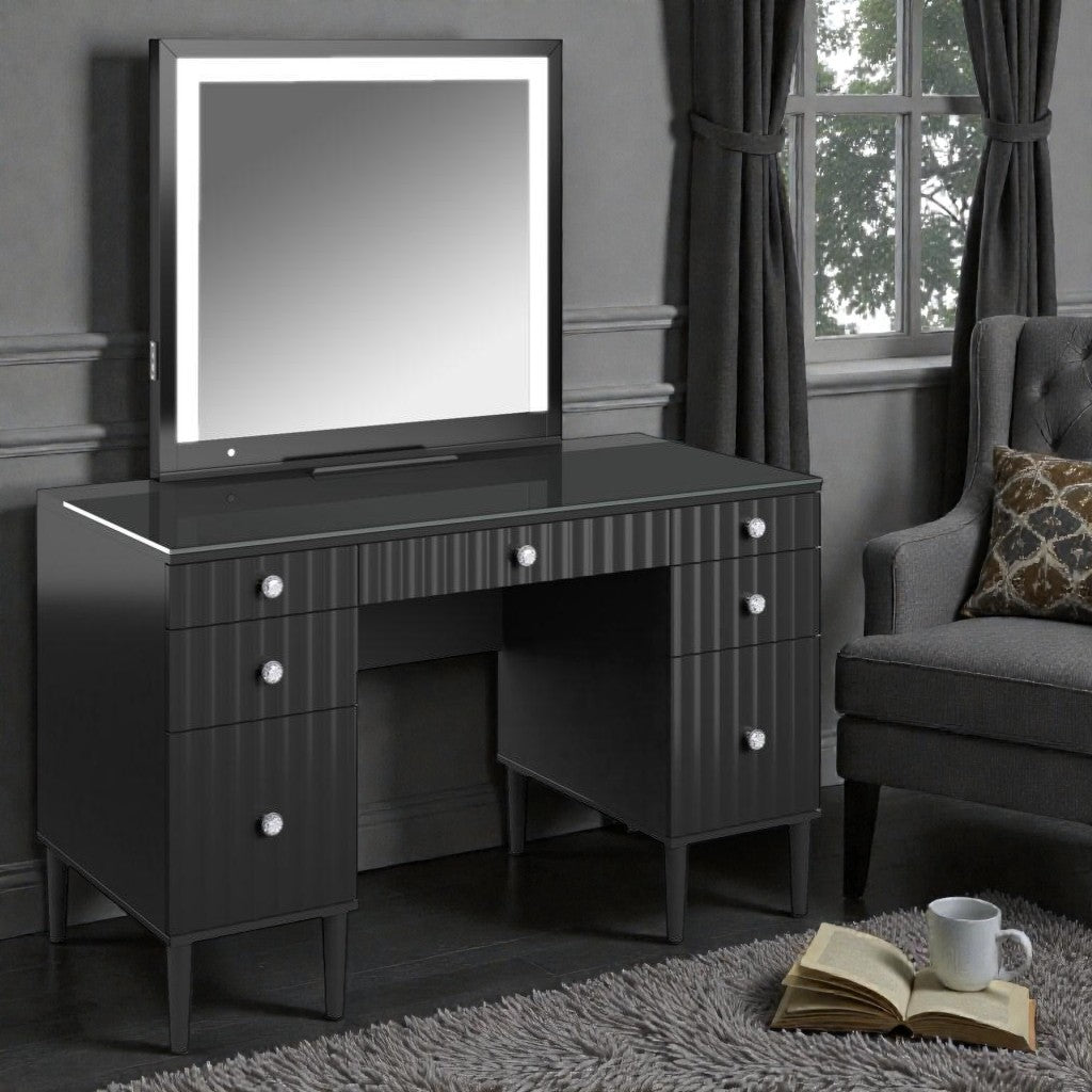Modern black vanity table with lighted mirror and crystal knobs in cozy gray room with armchair
