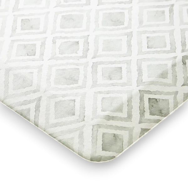 Close-up of textured fabric with a repeating light gray geometric square pattern on white background