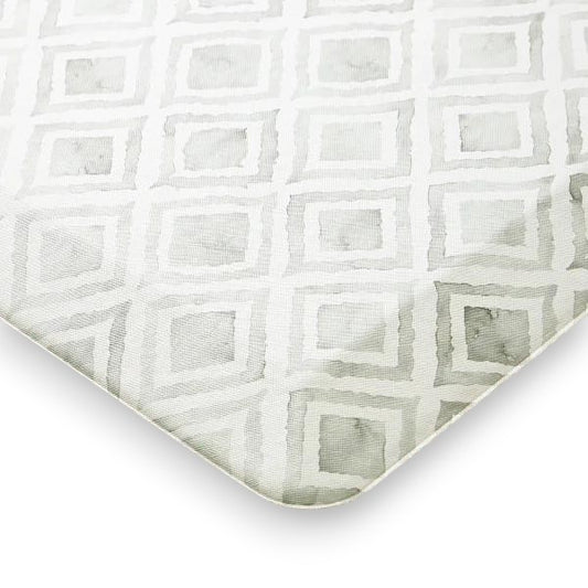 Close-up of textured fabric with a repeating light gray geometric square pattern on white background