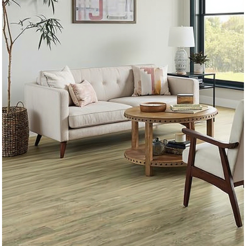 Modern living room with beige tufted sofa, wooden round coffee table, armchair, and large window