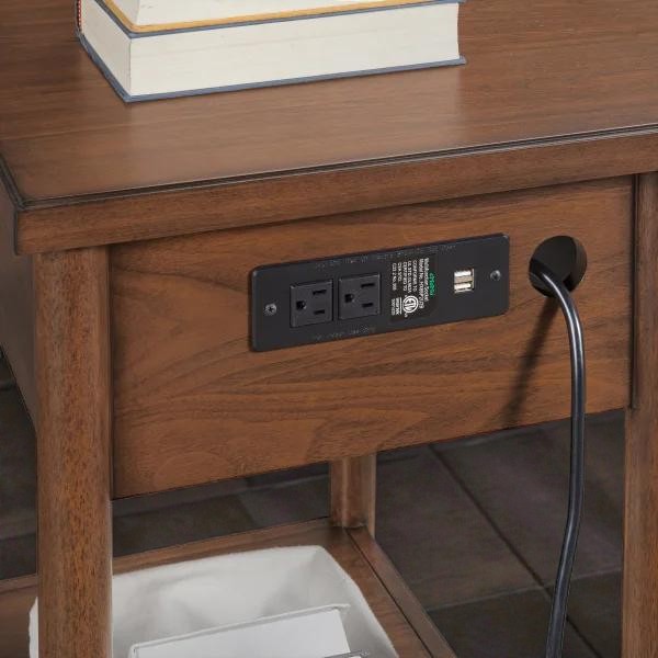 Wooden side table with built-in power outlets and USB ports, cord plugged in, books on tabletop