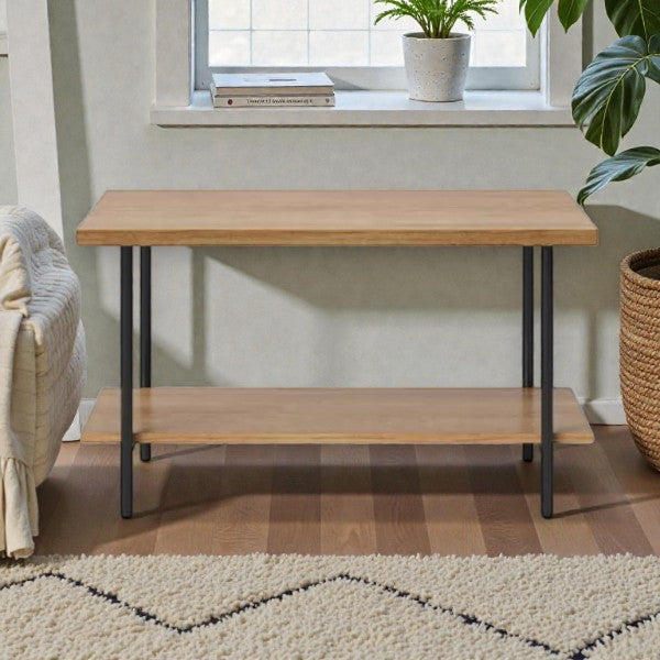 Wooden side table with black metal legs in a cozy living room near window, plant, and beige rug