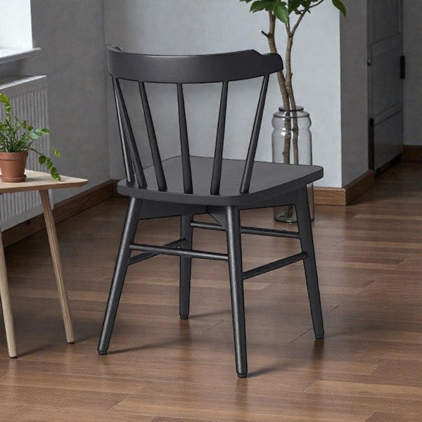 black wooden dining chair with spindle back on wooden floor in modern room with plants