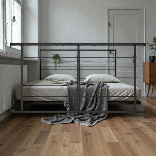 Minimalist bedroom with a modern metal frame bed, neutral bedding, gray throw blanket, wooden floor, and natural light