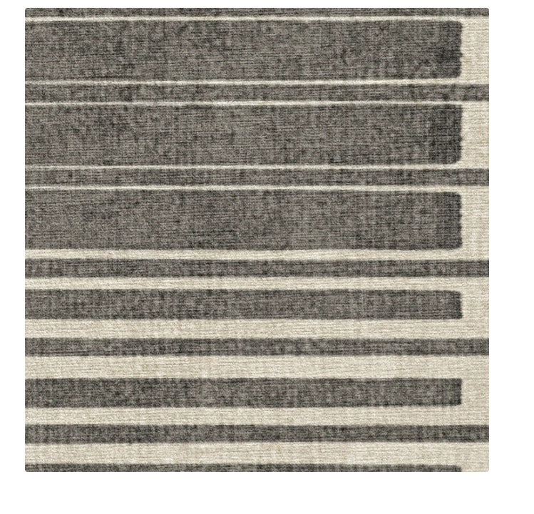 Modern area rug with horizontal gray and beige stripes in varying widths and textures