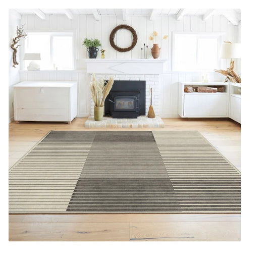 Modern living room with gray and beige striped area rug, white fireplace, and wooden floor
